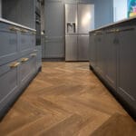 Ritz Oak Lacquered Wood Floor in grey Kitchen with brass handles