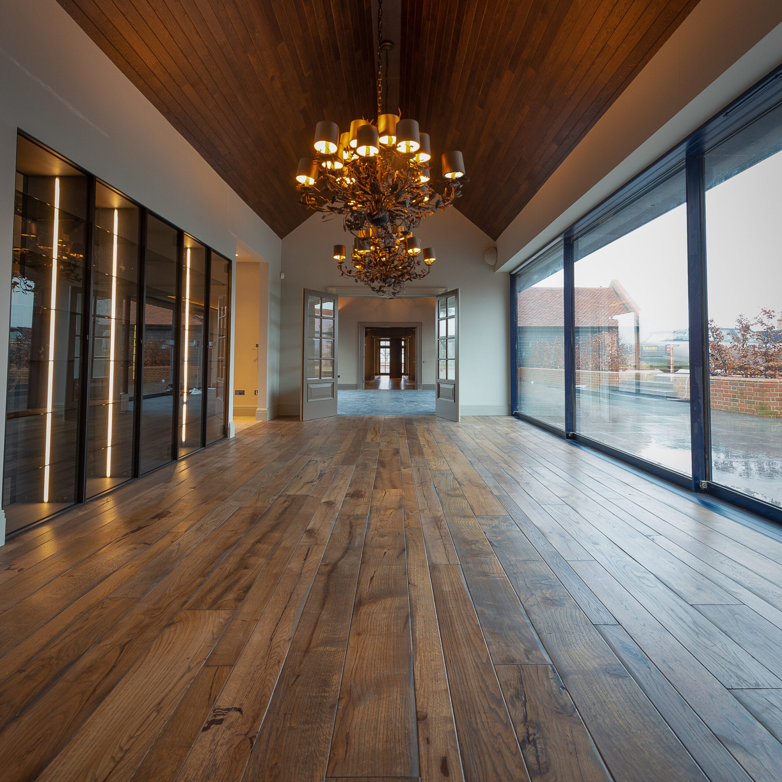 Reclaimed Oak flooring with vaulted ceiling and chandelier