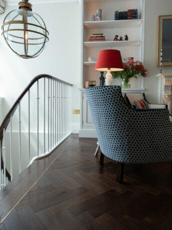 dark oak herringbone flooring with brass inset strip