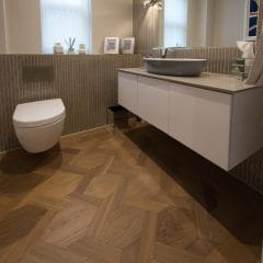 Mid tone wood floor in bathroom. Mansion weave parquet design
